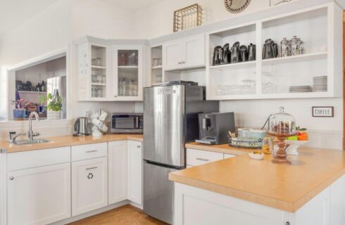 A kitchen with white cabinets and a refrigerator, creating a clean and modern aesthetic.